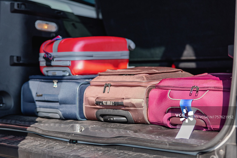 汽车后备箱装载不同颜色的行李箱图片素材