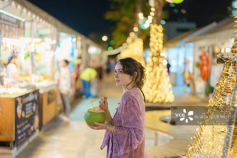 一名女子在曼谷夜市吃椰子冰淇淋图片素材