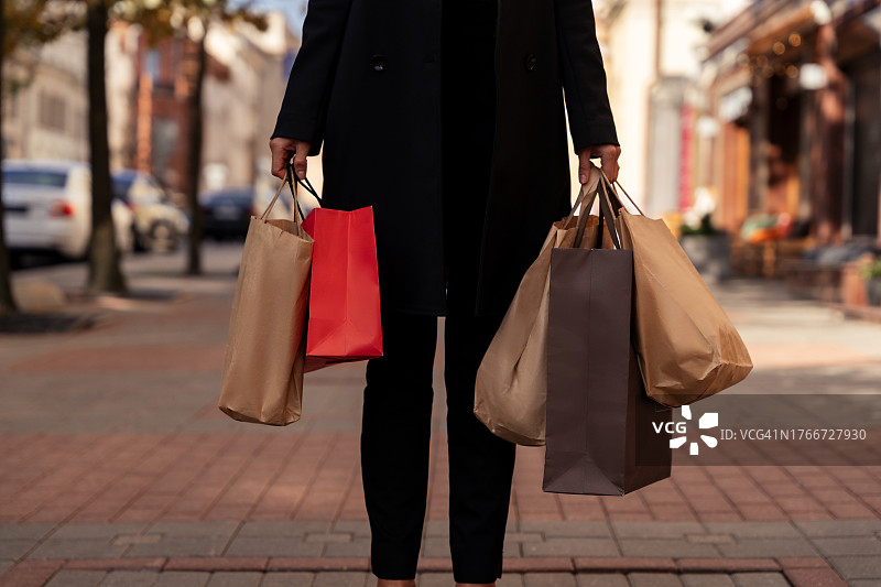 白俄罗斯，一位拎着购物袋走在街上的妇女的后视图图片素材