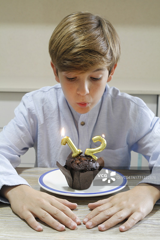 男孩吹灭了生日蛋糕上的蜡烛图片素材