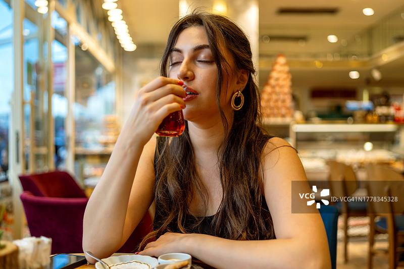 美女在街边餐厅喝土耳其热茶图片素材
