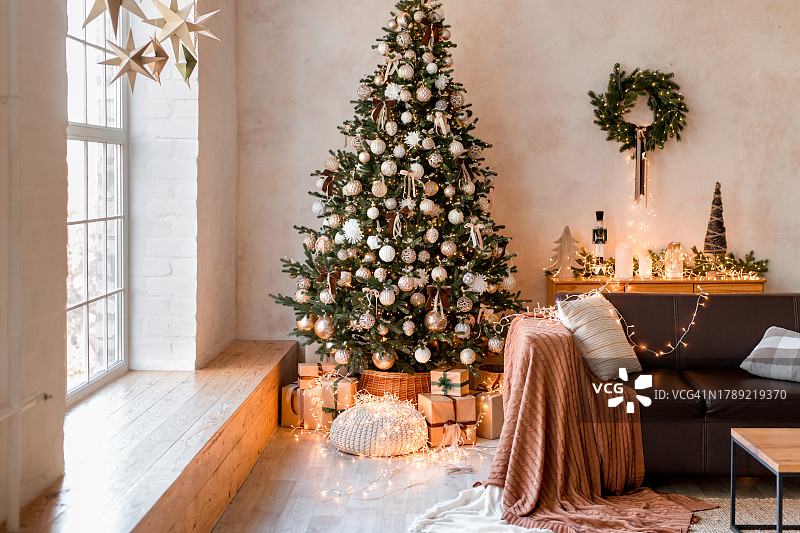 现代客厅内部，舒适的沙发，装饰着圣诞树和礼物图片素材