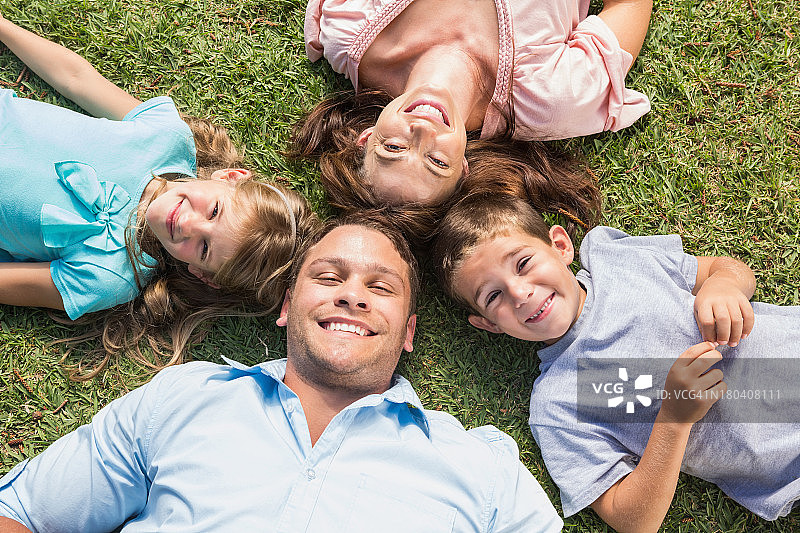 幸福的一家人躺在草地上围成一个圈图片素材
