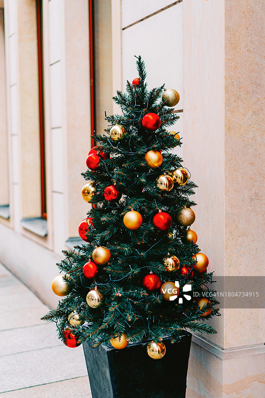 圣诞树上装饰着红色和金色的小玩意。新年庆祝理念。图片素材