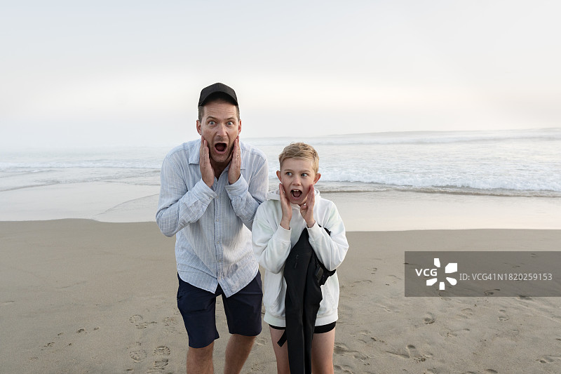 父子俩站在沙滩上做鬼脸图片素材