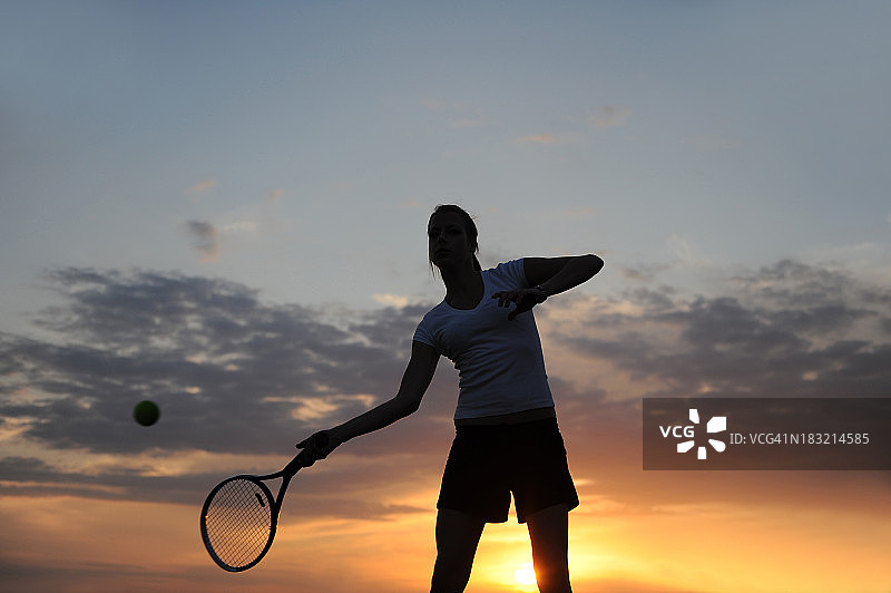 日落时的女子网球运动员图片素材