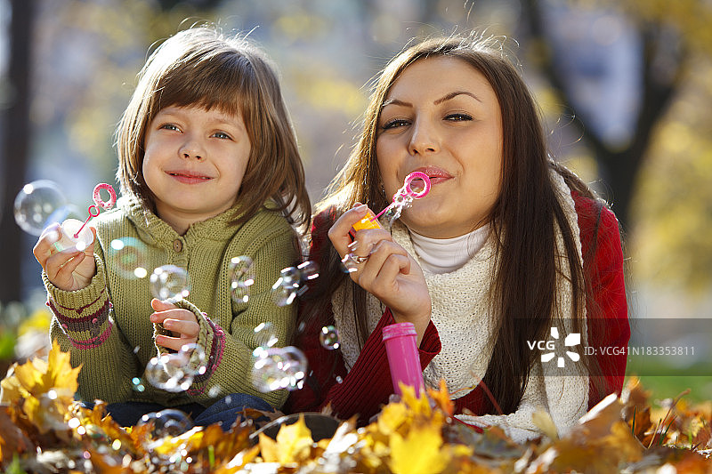 母亲和女儿在公园里享受秋天图片素材
