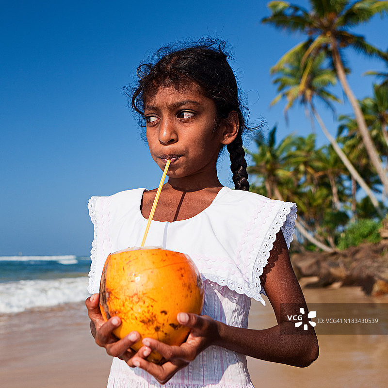 斯里兰卡小女孩和椰子的肖像图片素材