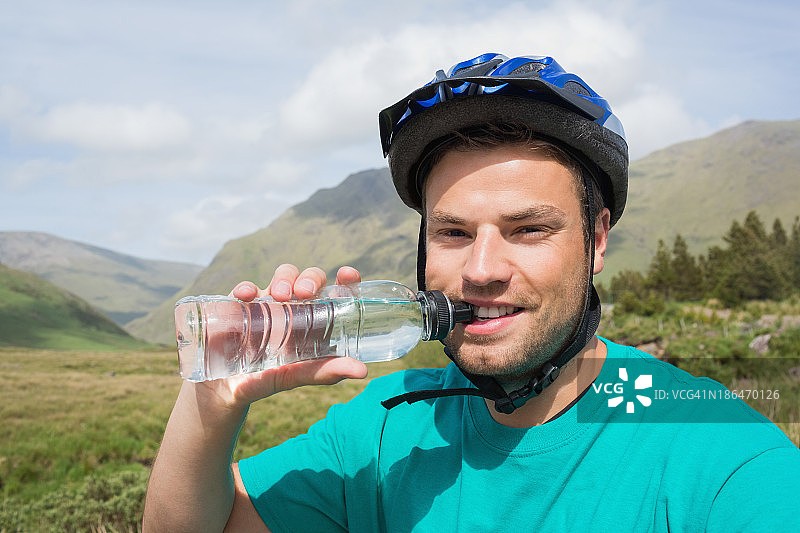 健康人戴着自行车头盔喝水图片素材