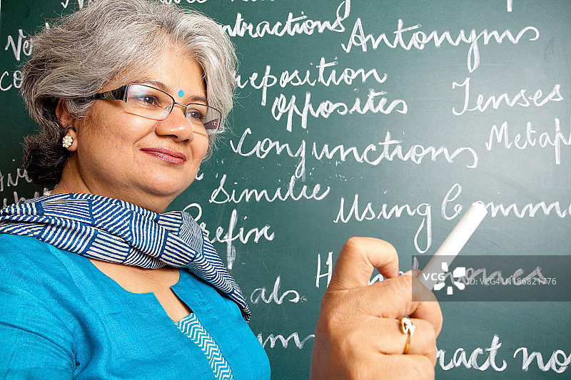 有吸引力的印度亚洲女英语老师在教室与greenboard图片素材
