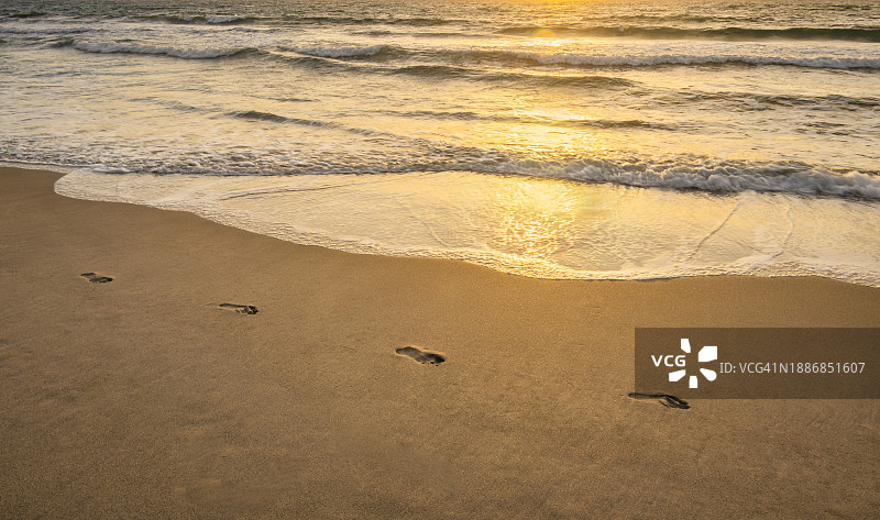 日落时沙滩上的脚印图片素材