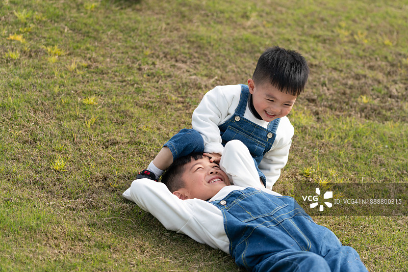 一对亚洲男孩在草地上玩耍图片素材