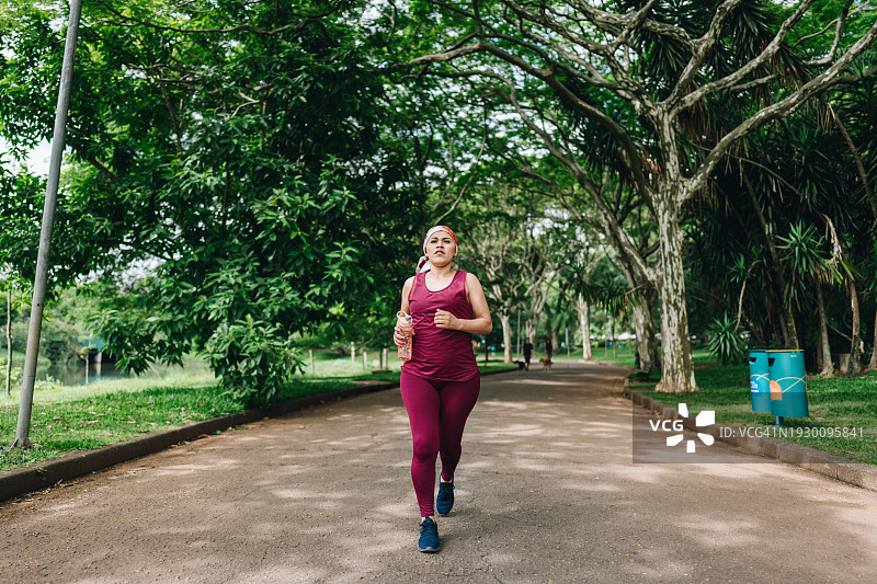 一个与癌症抗争的成熟女人在公园慢跑图片素材