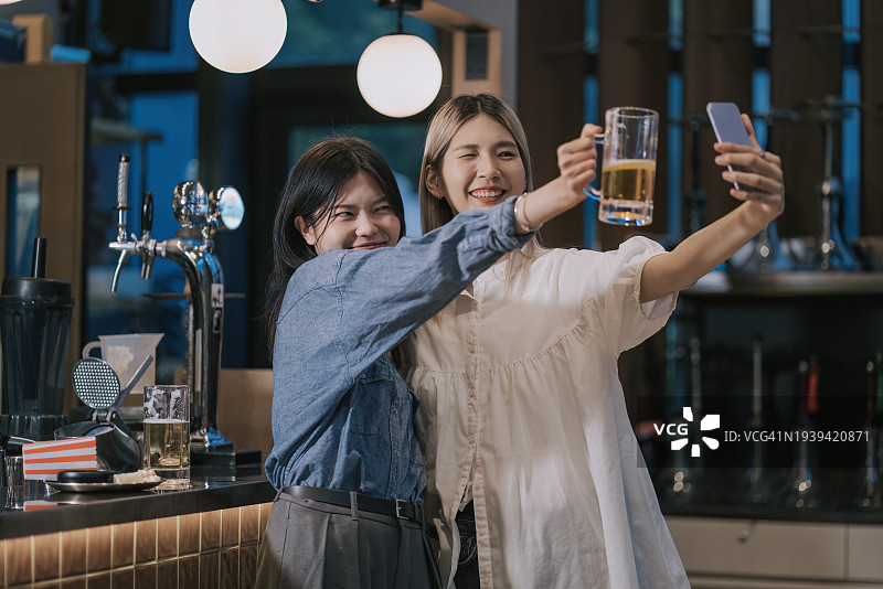 亚洲华人女性下班后在酒吧柜台自拍图片素材