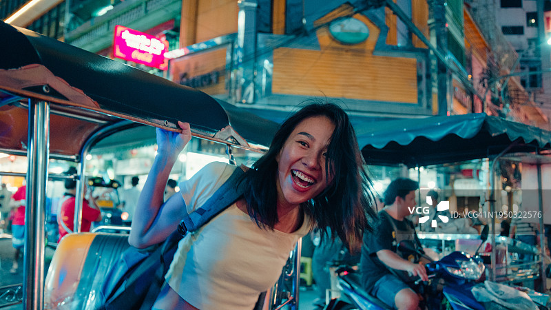 泰国曼谷街头，一名年轻的亚洲女游客乘坐一辆嘟嘟车。假日度假旅行。图片素材