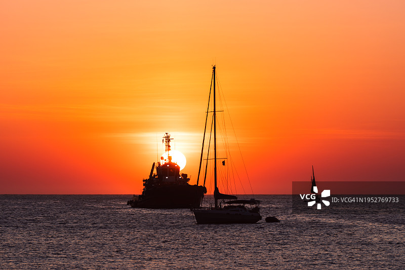 船在海上的剪影映衬着橙色的天空图片素材