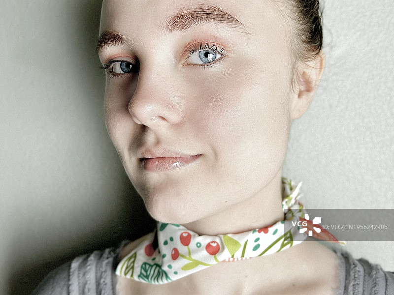 一个十几岁的女孩的肖像，蓝眼睛，戴着围巾。图片素材