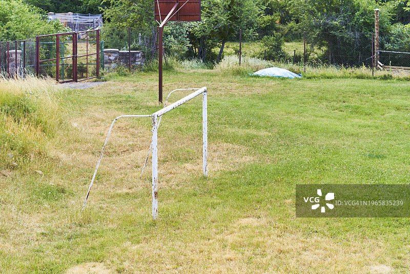 一个没有人的森林公园草地上的金属足球球的侧视图。图片素材