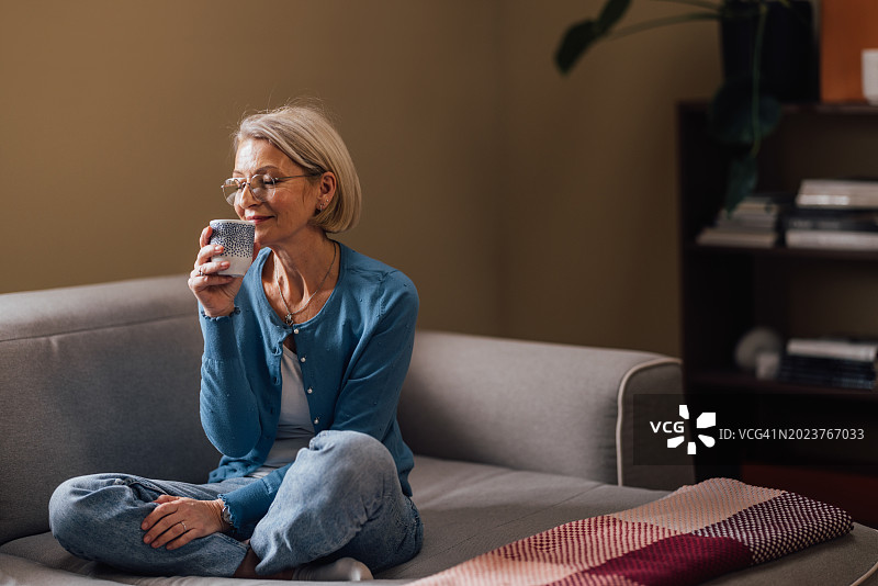 成熟的女人独自在家享受惬意的咖啡休息时间图片素材