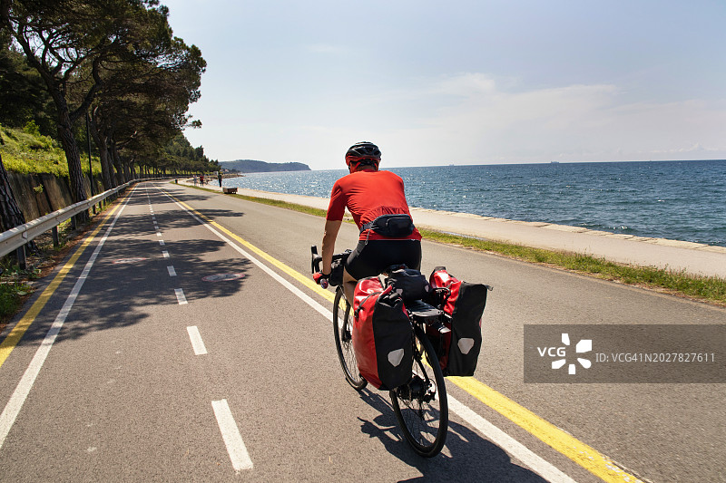 一名男子骑着自行车沿着亚得里亚海海岸骑行图片素材