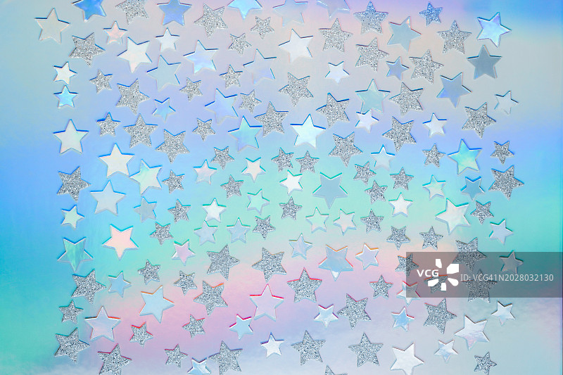 银星在一个柔和的全息彩虹背景图片素材