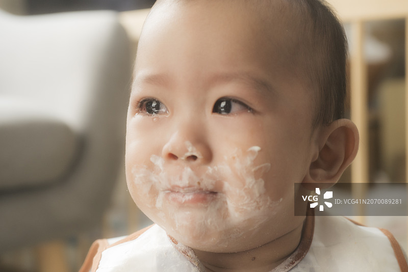 饥饿的10个月大的亚洲幼儿饭前哭喊:情绪化的用餐时间斗争图片素材