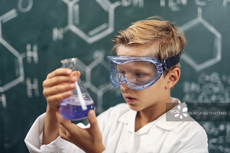小男孩科学家发明了一种新的化学溶液。图片素材