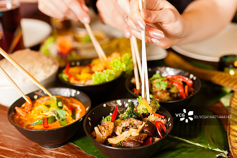 人们用筷子吃泰国菜图片素材