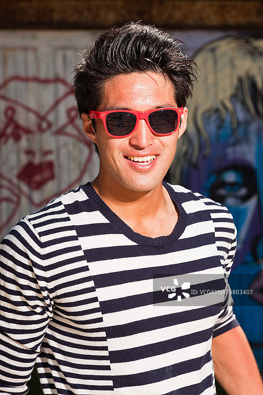 都市亚洲男人戴着红色太阳镜。好看。很酷的家伙。图片素材