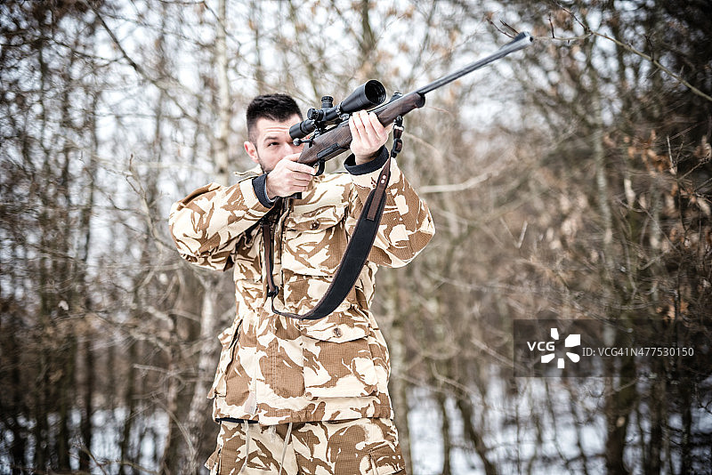 狙击手与武器准备战斗或狩猎在冬天图片素材