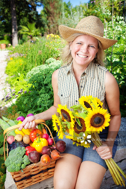 采摘新鲜的夏季花卉和蔬菜从花园垂直图片素材