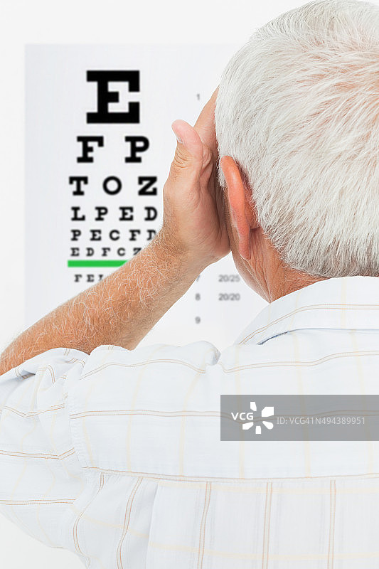 一位年长男士看视力表的后视图图片素材