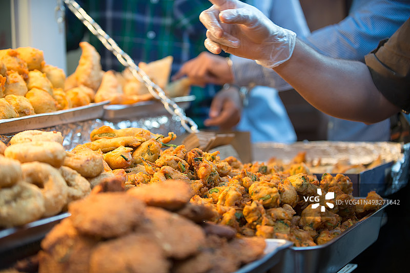 繁忙的街头小吃小贩出售印度炸丸子，萨莫萨和零食图片素材