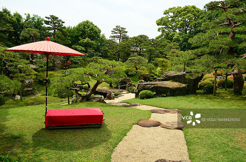 红伞和长凳在Keiunkan花园图片素材