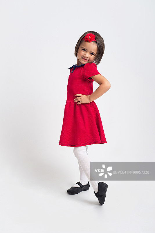 漂亮的小女孩微笑着穿着红裙子图片素材