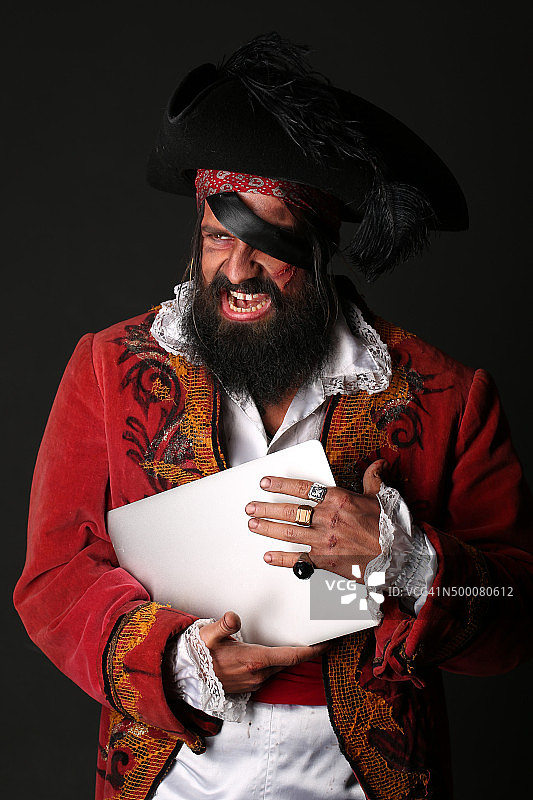 一个穿着海盗服装拿着笔记本电脑的男人的肖像图片素材