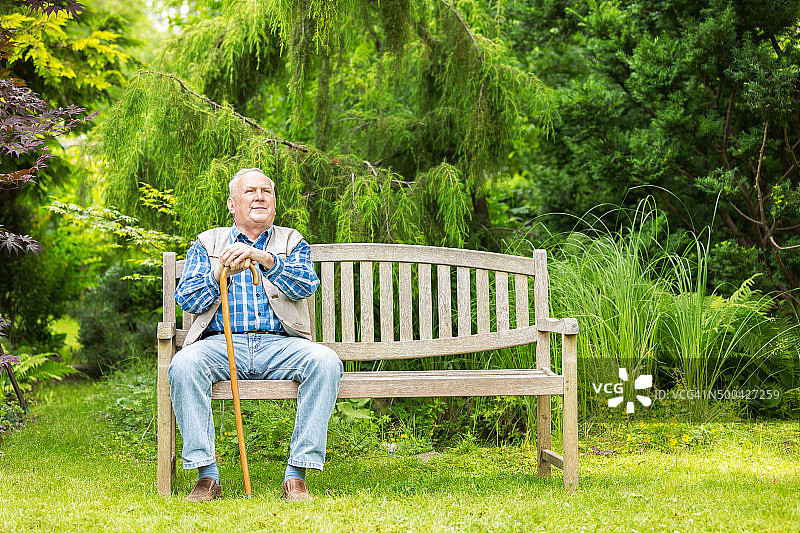 老人坐在公园的长椅上图片素材