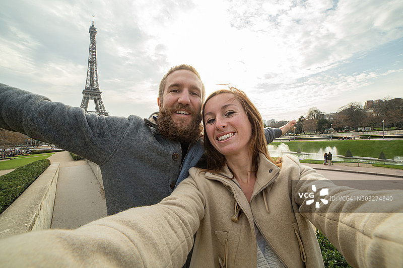 一对年轻夫妇在巴黎埃菲尔铁塔自拍图片素材