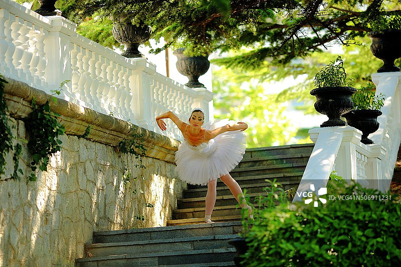 美丽的芭蕾舞演员在公园的楼梯上跳舞图片素材