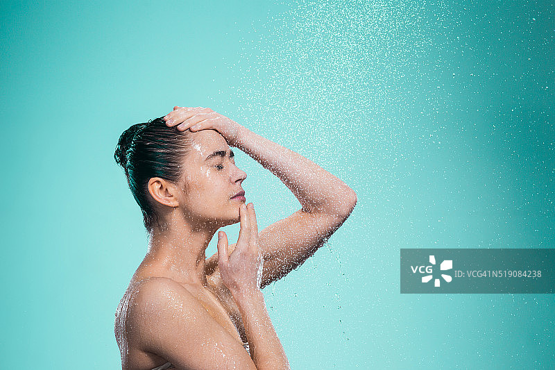 在喷水下享受淋浴的女人图片素材