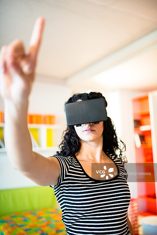 女大学生在家使用虚拟现实模拟器图片素材