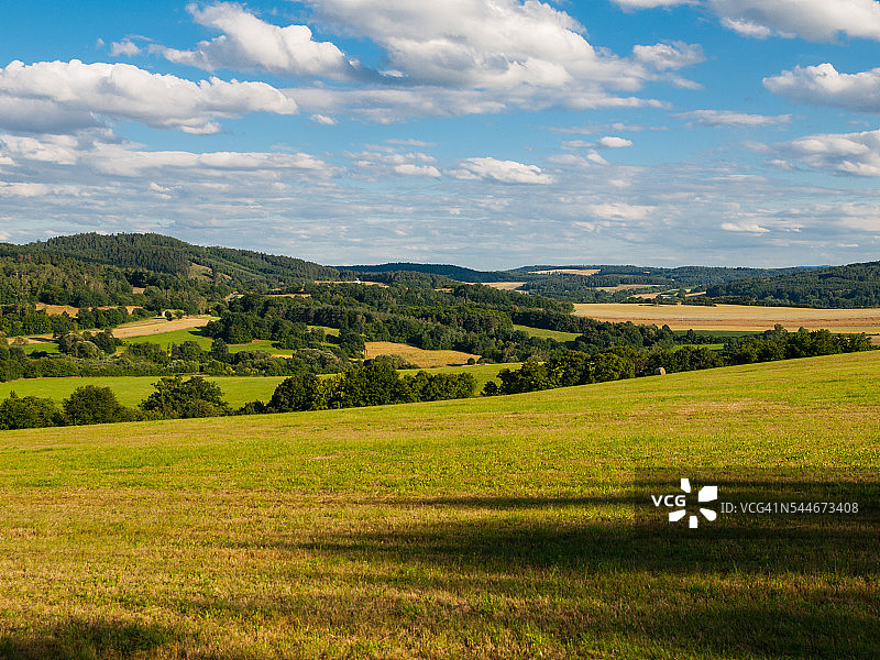 夏季的山地景观有绿色的原野、森林、蓝天图片素材