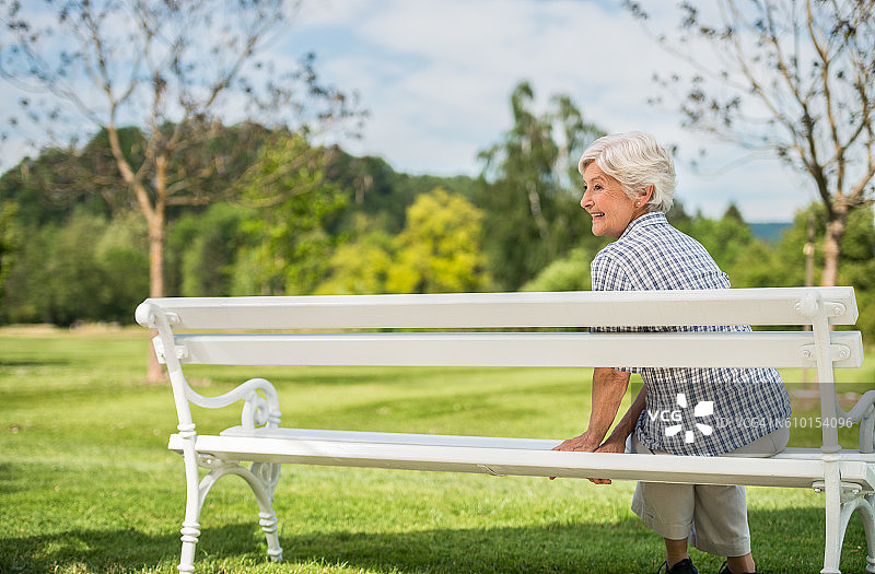 坐在公园长椅上的资深女性图片素材