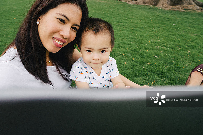 快乐的母子在户外平板电脑上上网图片素材