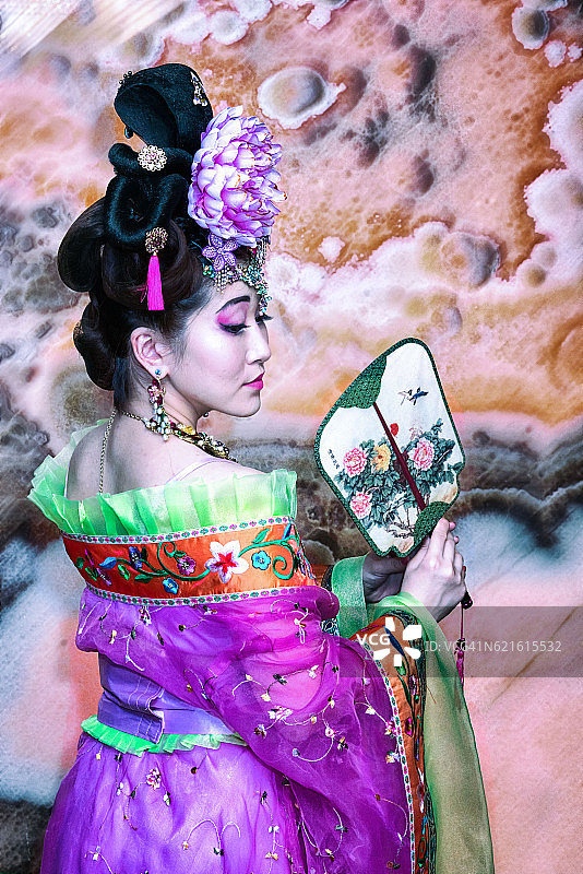 中国女孩穿着传统服装用扇子，后视镜转图片素材