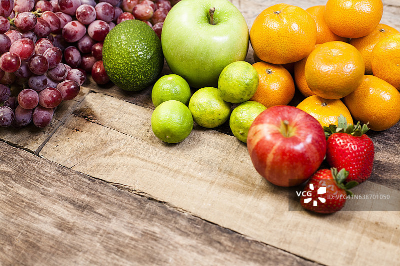 新鲜、有机的五颜六色的水果放在质朴的木桌上。图片素材