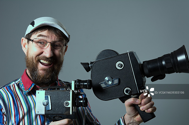 笑嘻嘻的大胡子男人，两台老式复古胶片相机图片素材