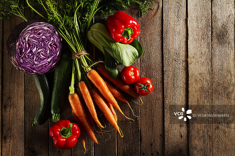 食物蔬菜彩色背景。美味新鲜的蔬菜在木桌上。顶部视图与复制空间。水平的。图片素材