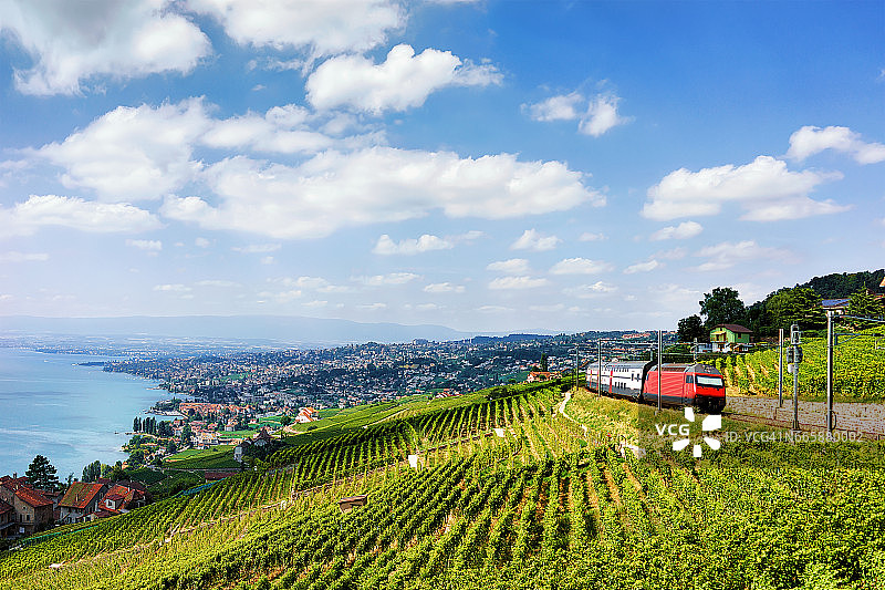 火车在拉沃葡萄园梯田附近的日内瓦湖瑞士山脉图片素材