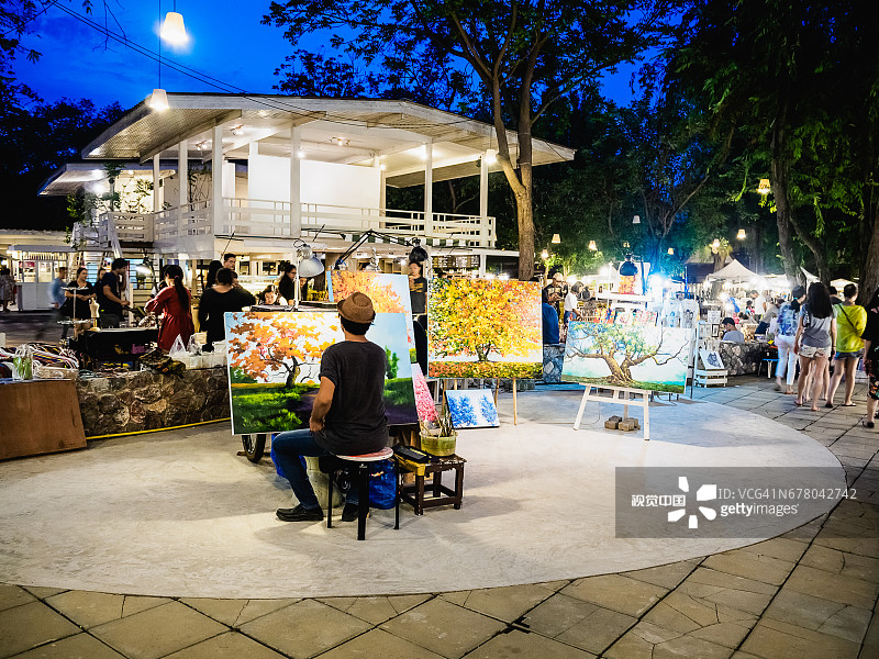 一位画家正在泰国华欣的蝉夜市画画。图片素材